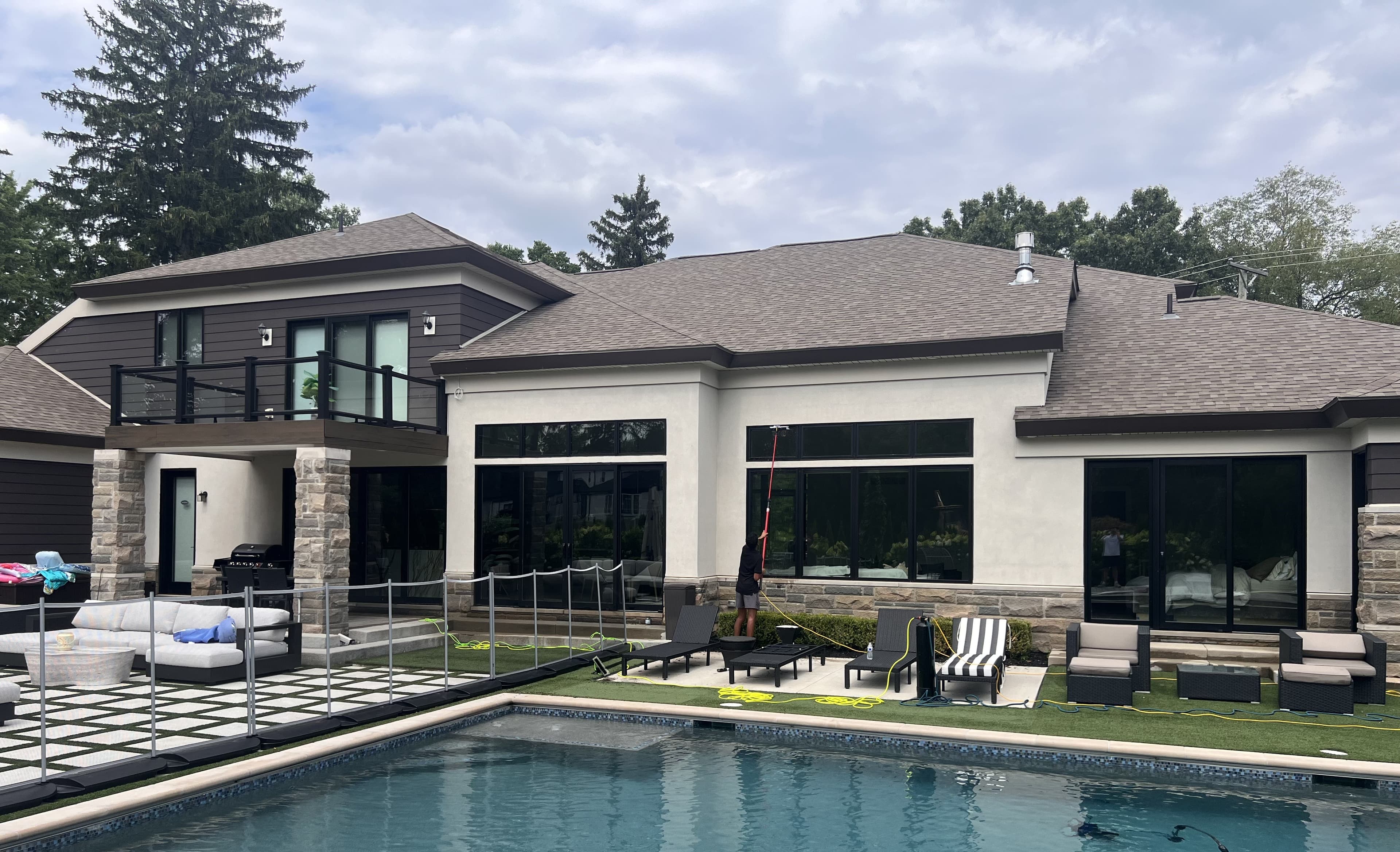 Bloomfield Window Cleaning technician using a water-fed pole to clean the windows of a luxury Bloomfield Hills home